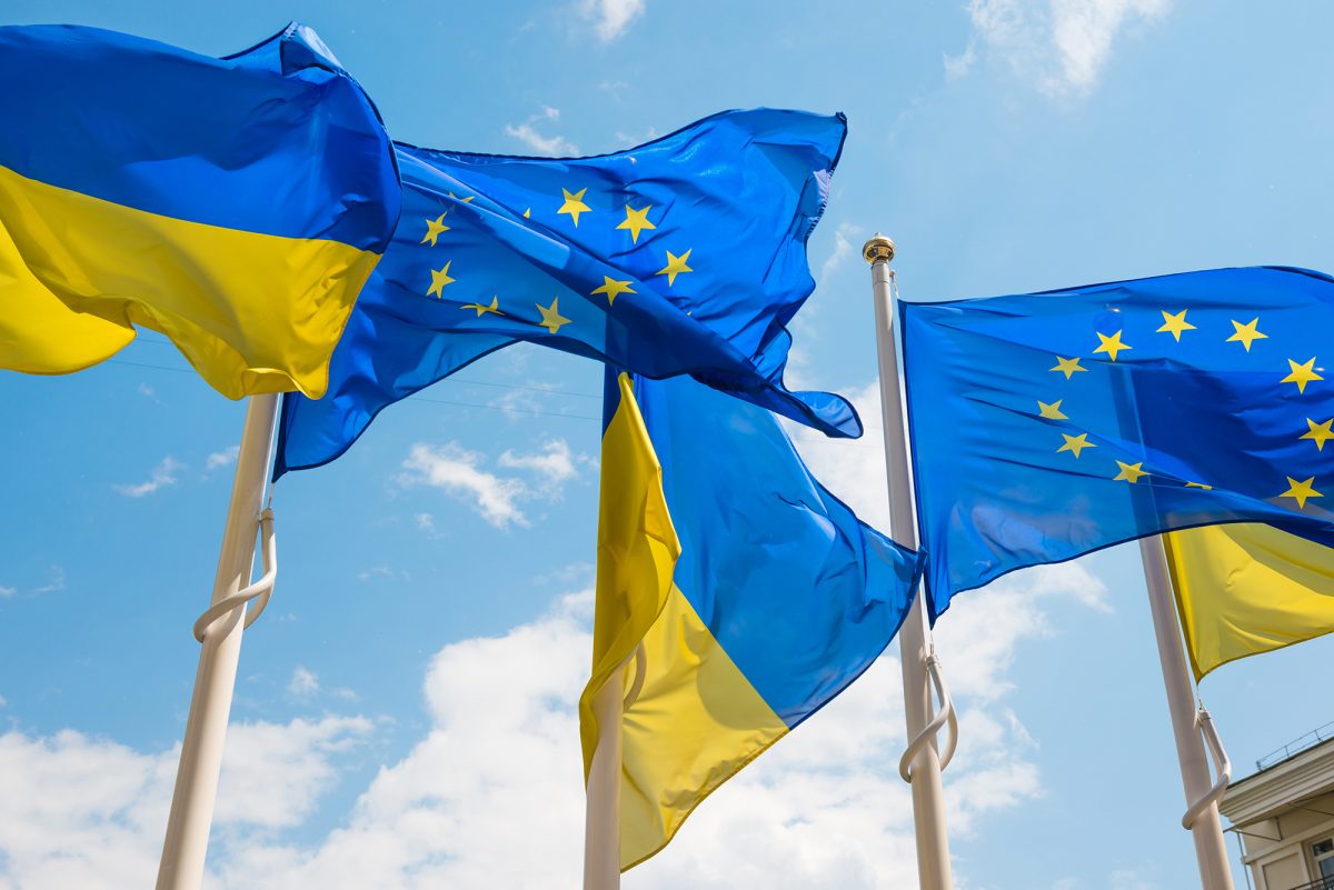 Flagpoles With European Union And Ukraine Flags On Blue Sky Back