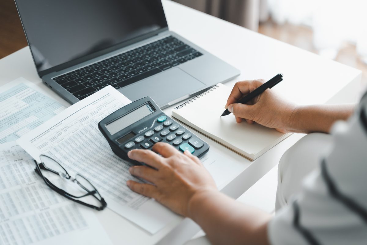 Woman Is Calculating Annual Tax, Monthly Expenses With Calculato